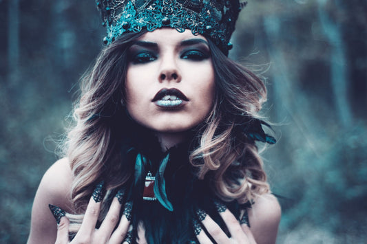 Vrouw met donkere, glamoureuze Halloween-make-up en kroon