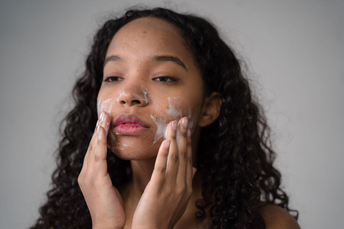 Vrouw reinigt haar gezicht mild met water - microbioom-vriendelijke skincare